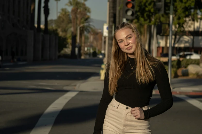 a pretty young lady standing on the side of a road