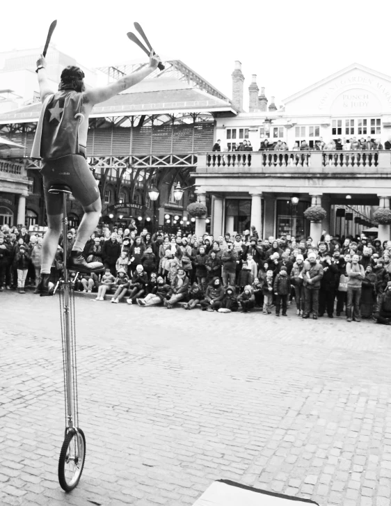 a man is riding an old fashioned unicycle through the street