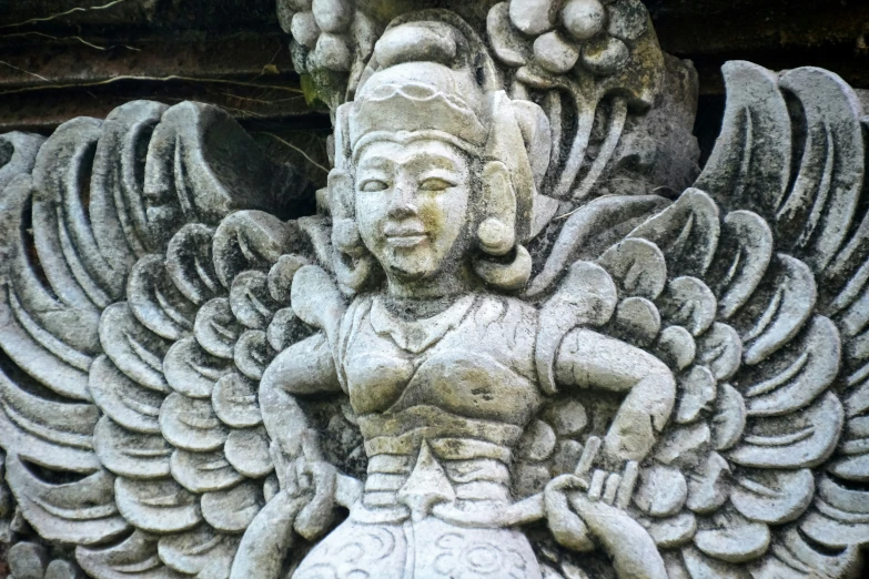 a statue of an angel with two hands and fingers in front of it