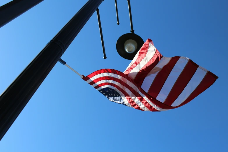 the american flag is hanging from a light post