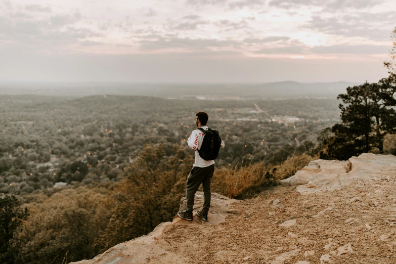 a man is standing on top of a hill