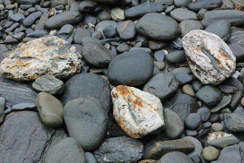 several large rocks are on the shore of the ocean