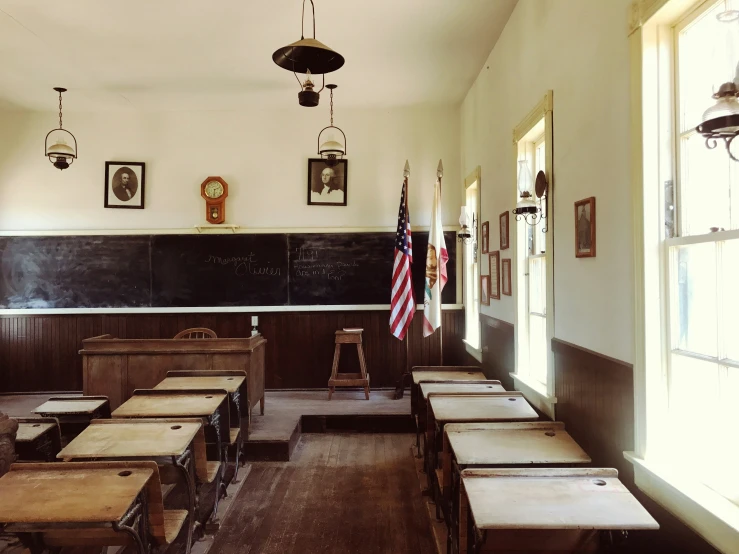 an empty classroom with desks and american flags