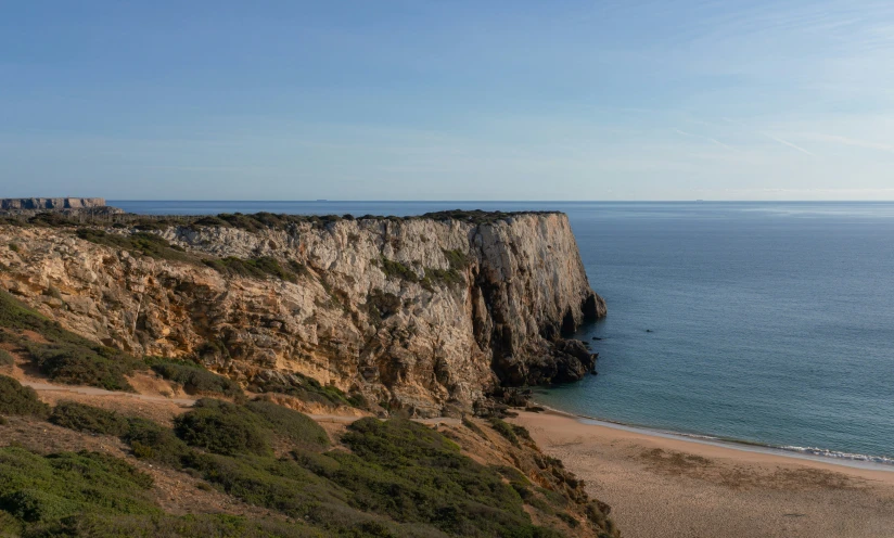 a view of an ocean and cliff from a beach