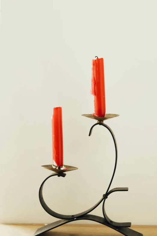 two red candles on a table with one red