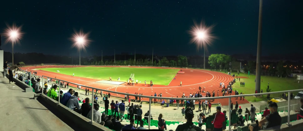 an outdoor tennis stadium with lights on at night