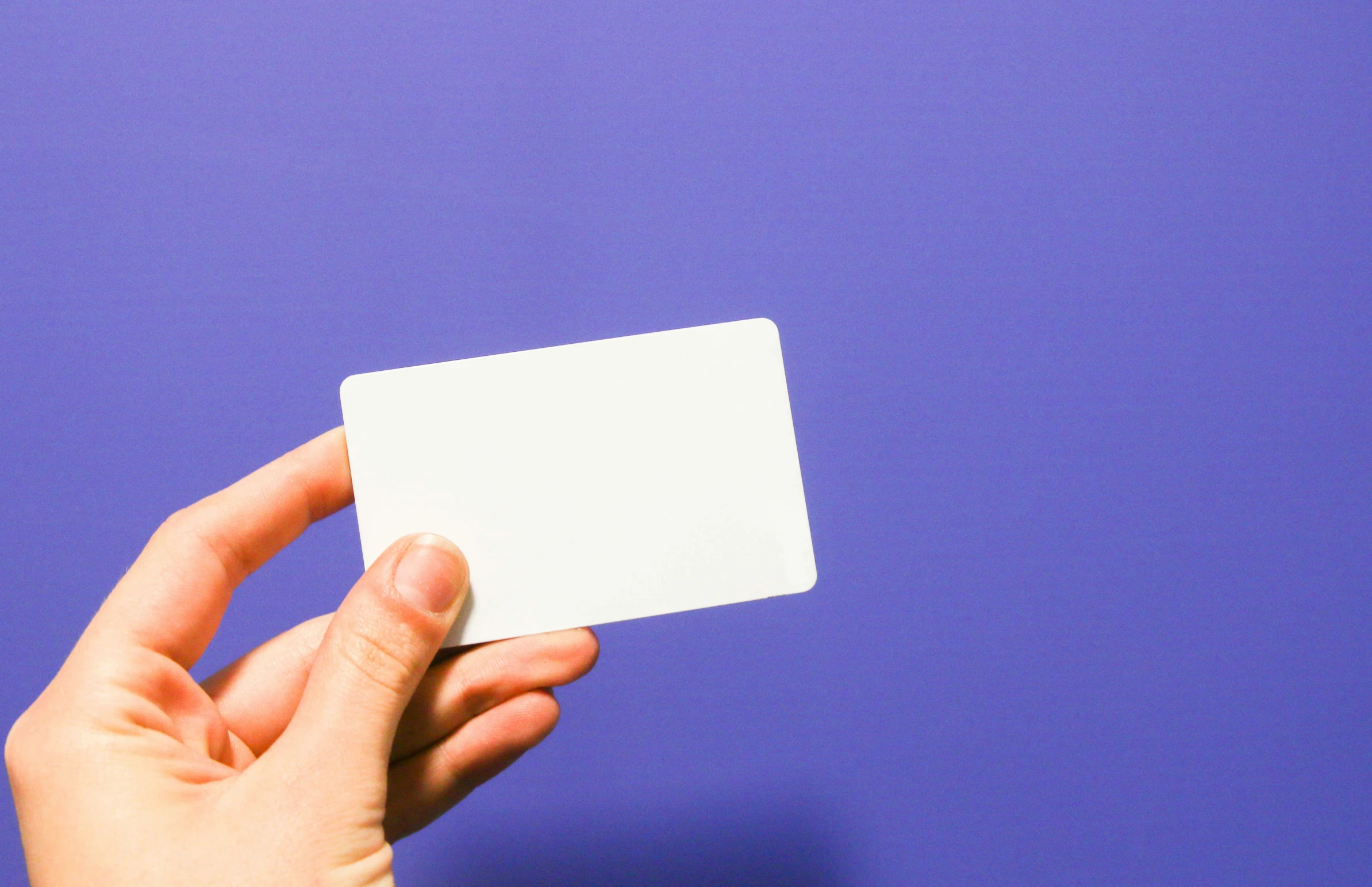 a person holds an empty white paper card