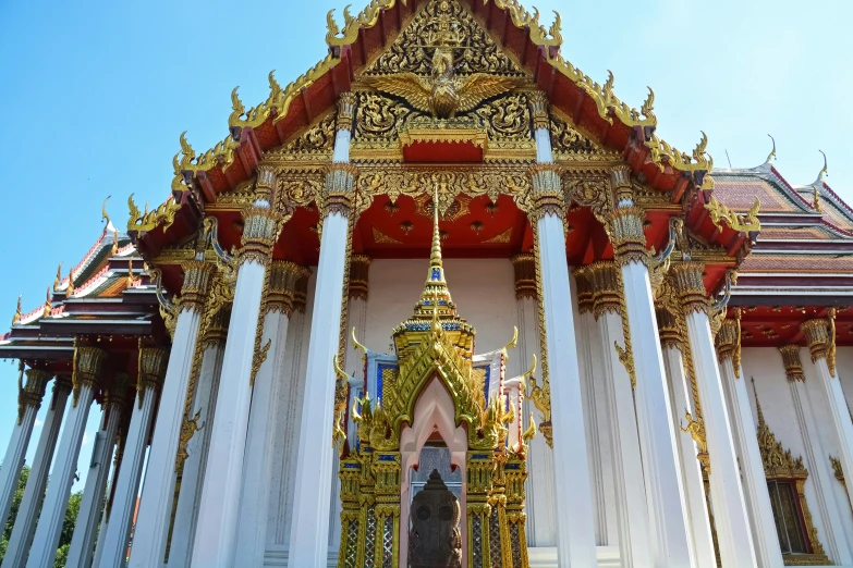 a gold and white building is decorated with columns