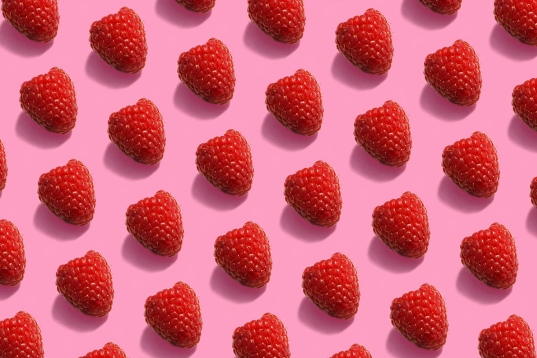 a large group of strawberries on a pink background