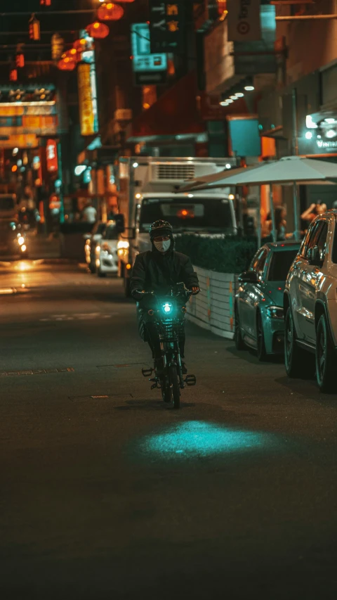 a biker on a road next to vehicles