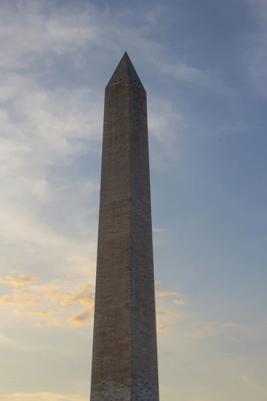 an obelisk with the sun setting in the background
