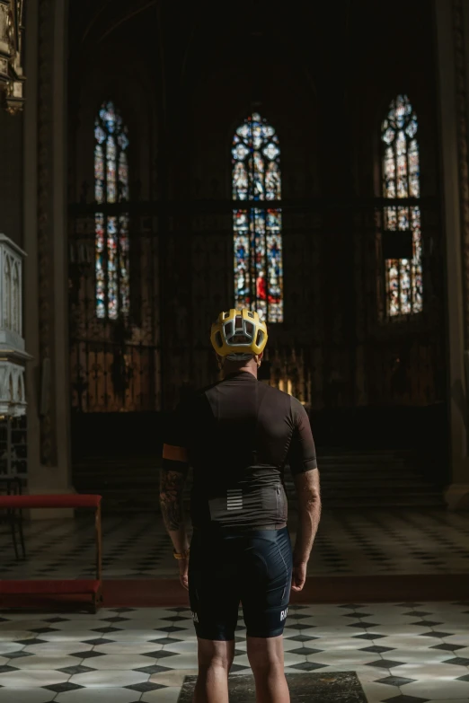 a man wearing a yellow helmet inside a cathedral