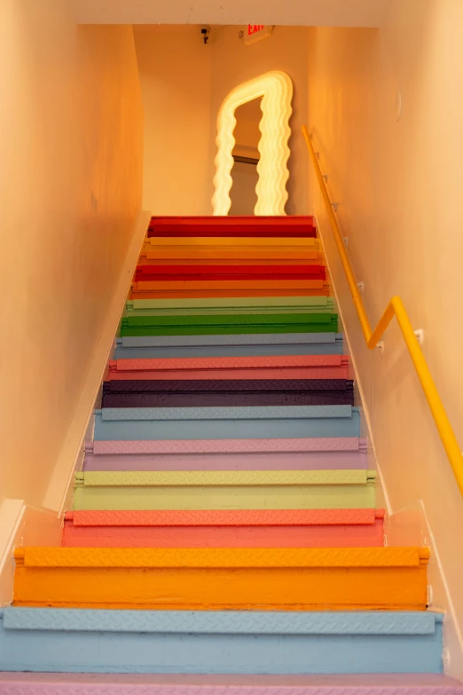 a set of colorful painted stairs next to a neon lit area