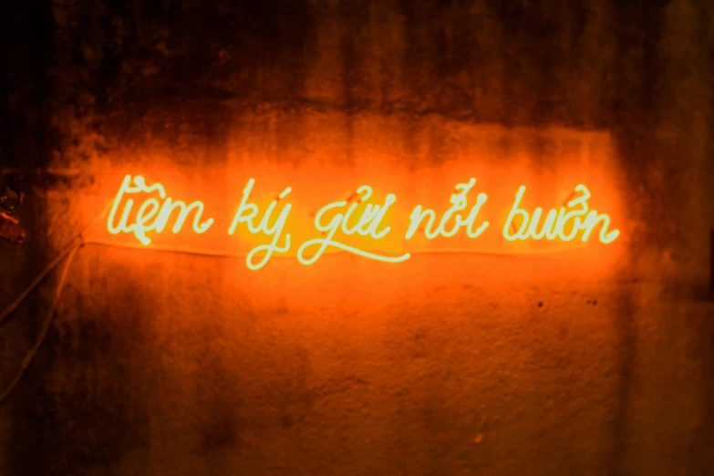 a neon sign in a dark area reads,'i am by gin but burn '