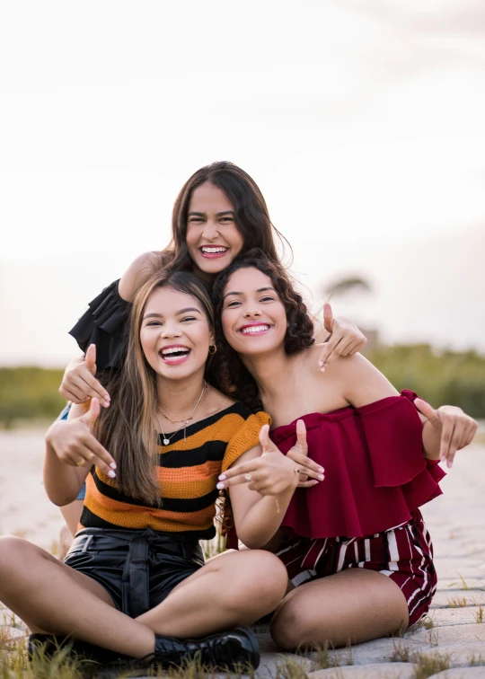 three young women sitting next to each other posing for the camera