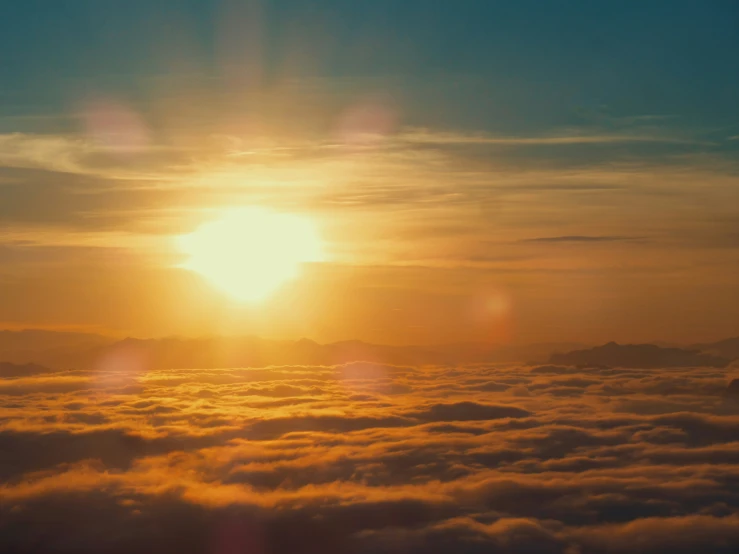 the sun is setting above the clouds in the sky