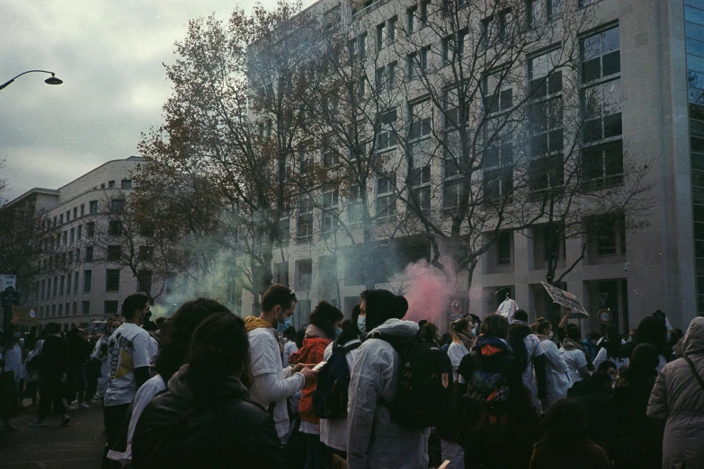 a crowd of people standing next to each other on a city street