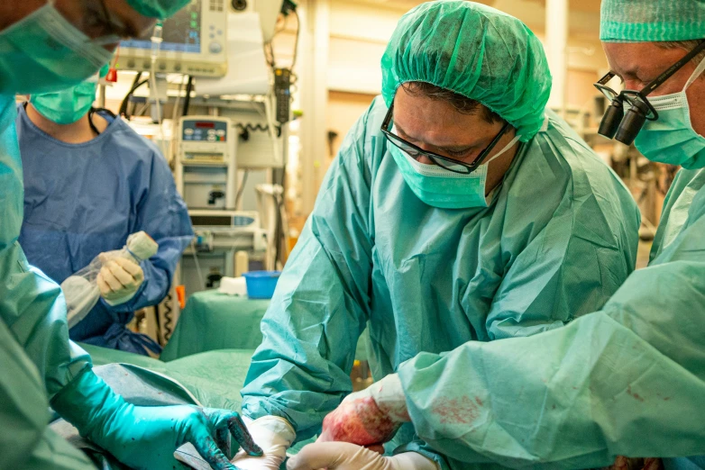 medical personnel in surgical gear perform an operation