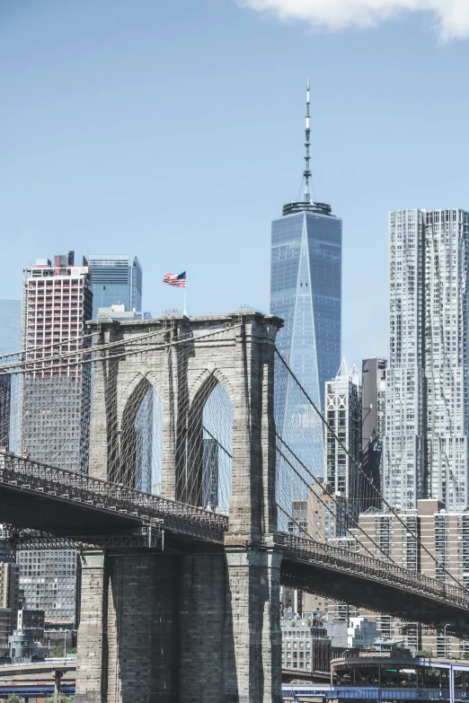 this bridge is going over the water with lots of tall buildings in the distance