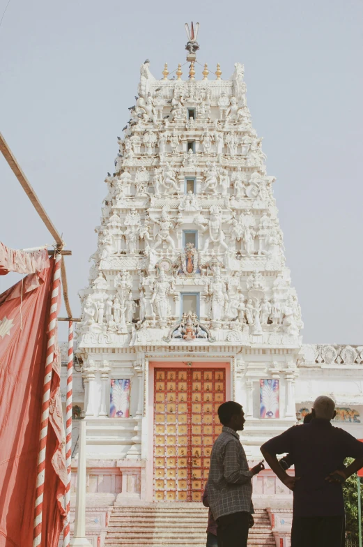 two people standing in front of an ornate white building