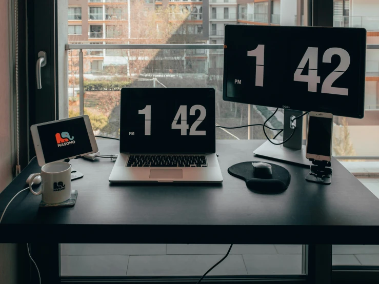 a laptop computer and two monitors sitting next to each other