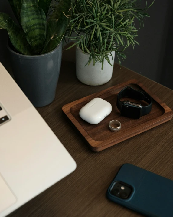 a white computer monitor on a table and a wood tray