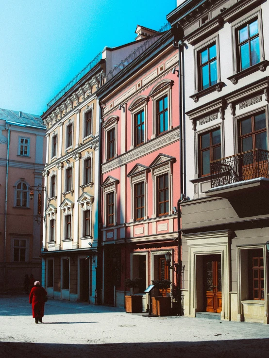 several buildings in the daytime with one woman walking