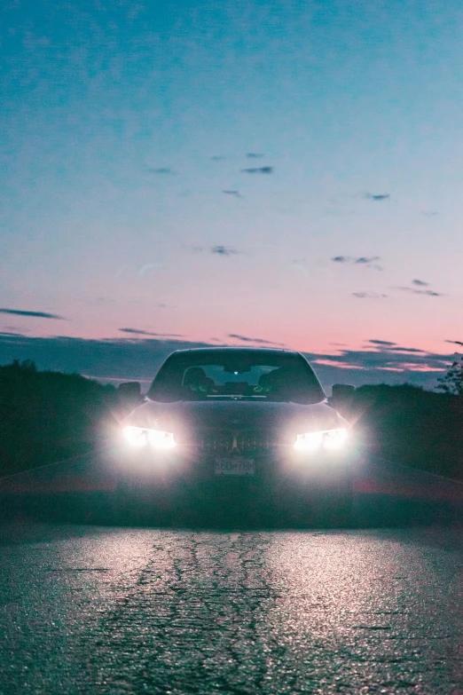 a black sports car at night driving on the road