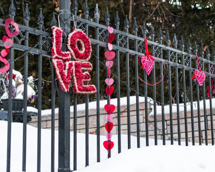 a bunch of love hearts attached to a fence