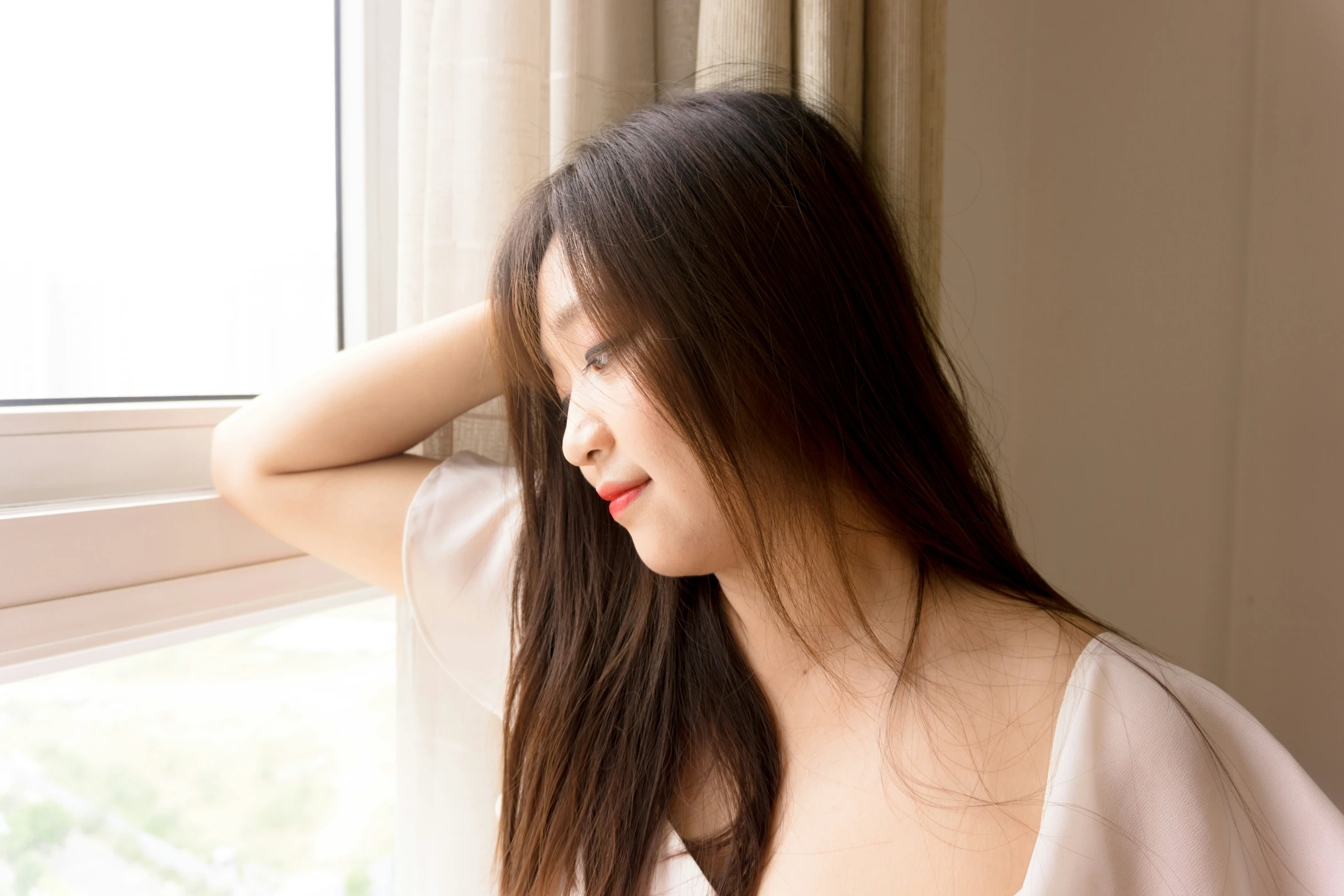 a woman is leaning against the window sill