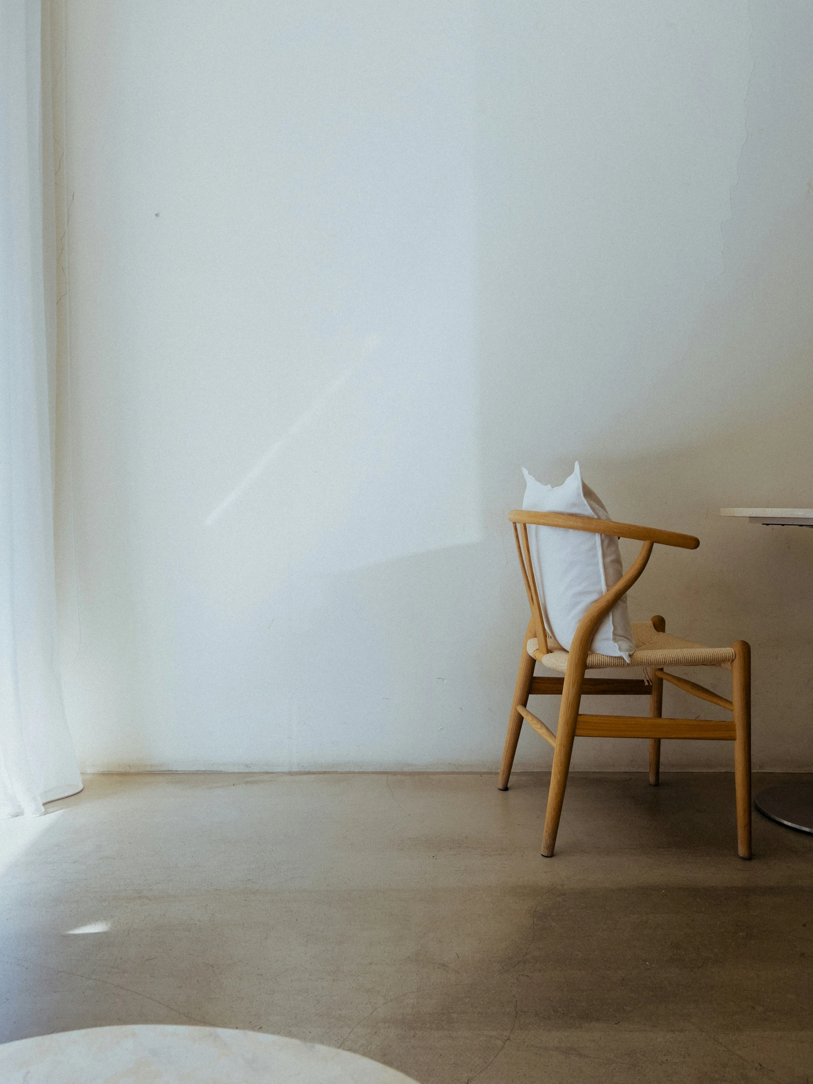 an empty chair in front of a white wall