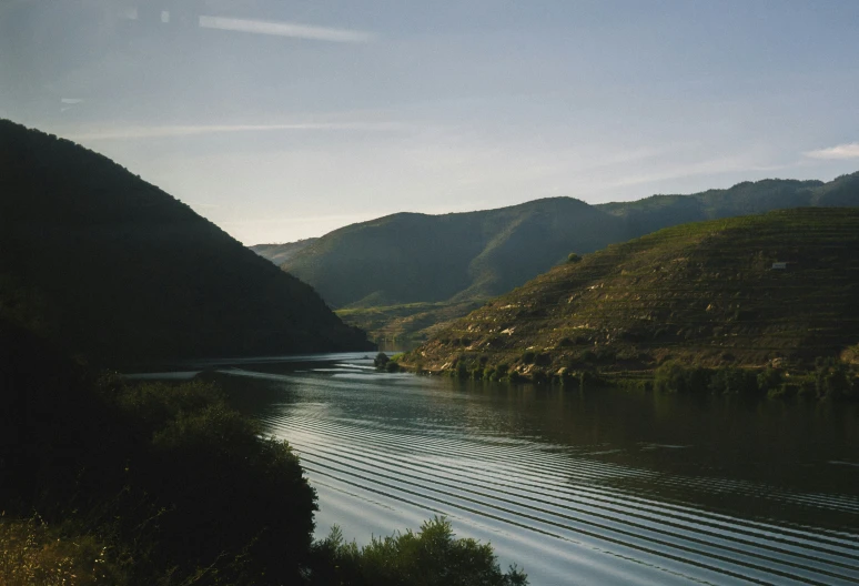 river surrounded by hills in the countryside