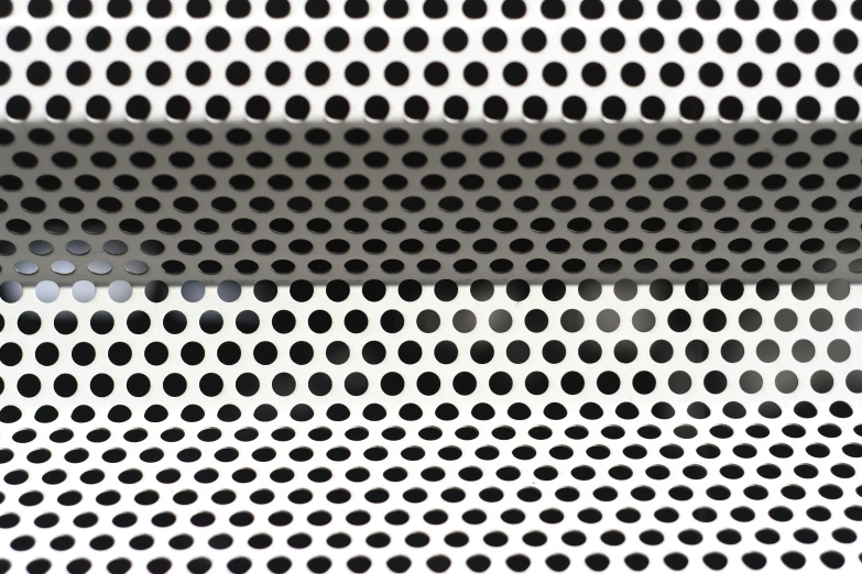 a bunch of small black dots are seen against the white backdrop