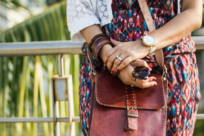 woman with a red purse standing next to a railing