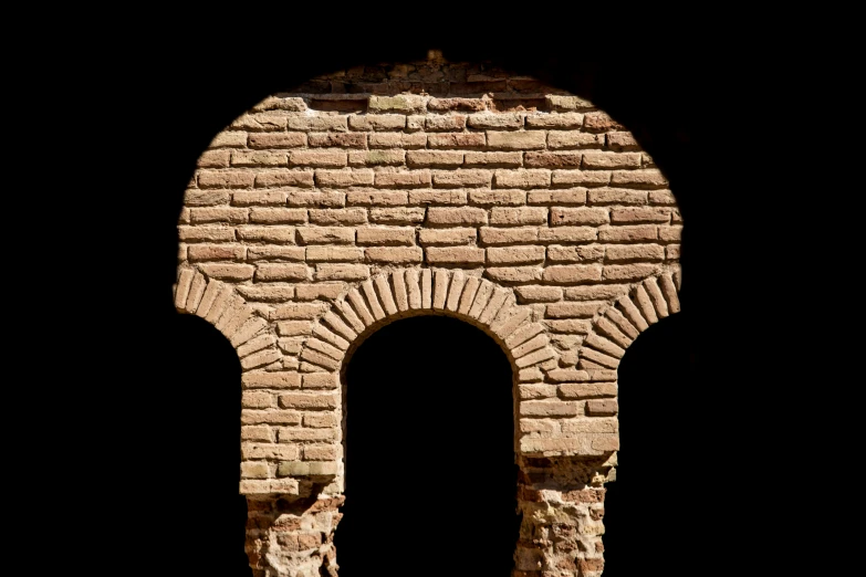 an arch in a brick wall that looks like a stone wall