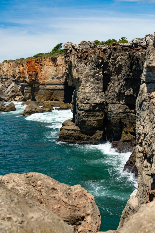 some large rocks and water with a clear blue sky