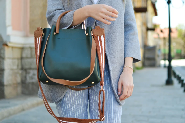 the person carrying a green handbag is wearing a white shirt