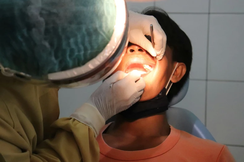 a person with a light up nose and a dentist wearing safety gloves