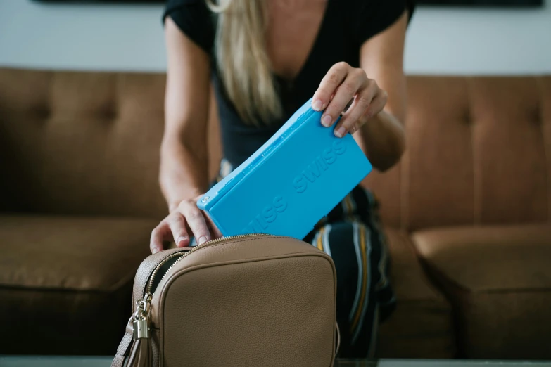 a woman holds a blue piece of luggage in her hand