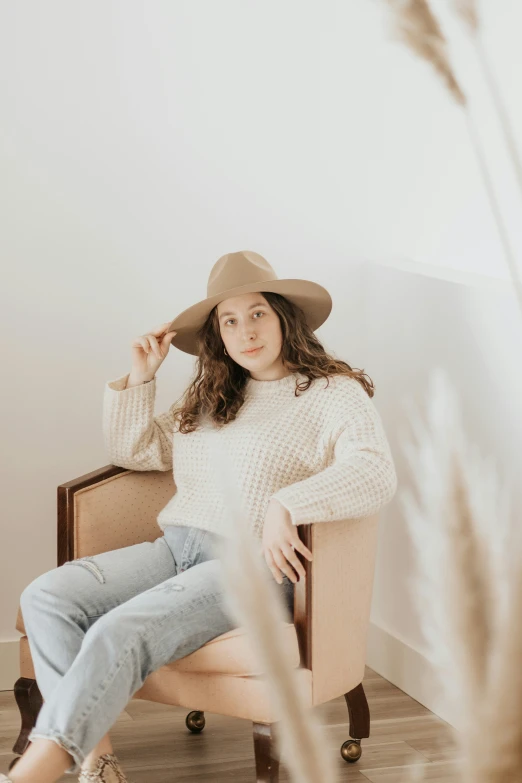 a woman in a brown hat and white sweater