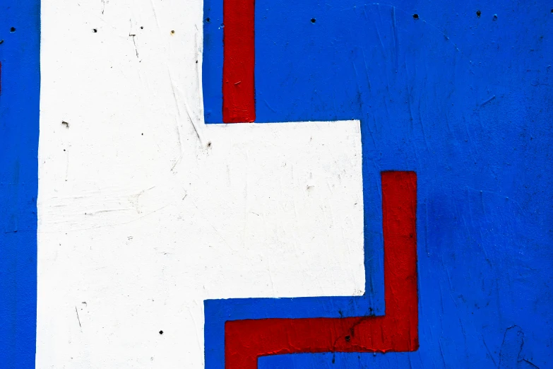 a red white and blue block that is next to a white wall