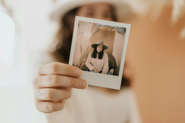 a person holding up an polaroid with a monkey on it