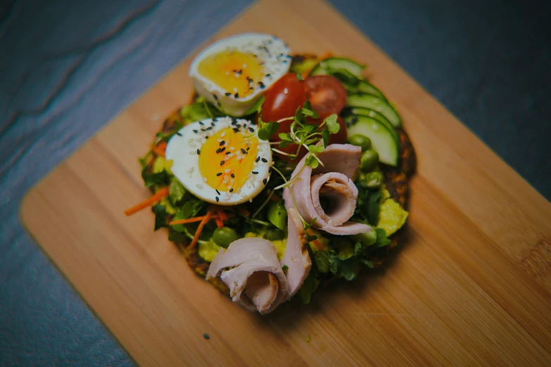 a salad on a wood  board with egg on it