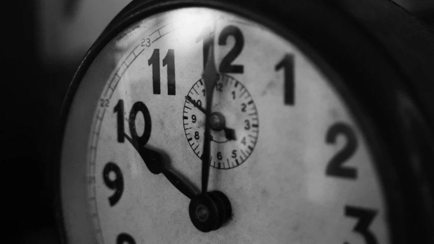 closeup of an analog clock face showing 11 55