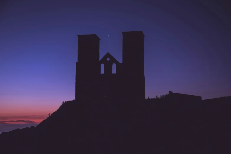 silhouette of two buildings with windows at the top