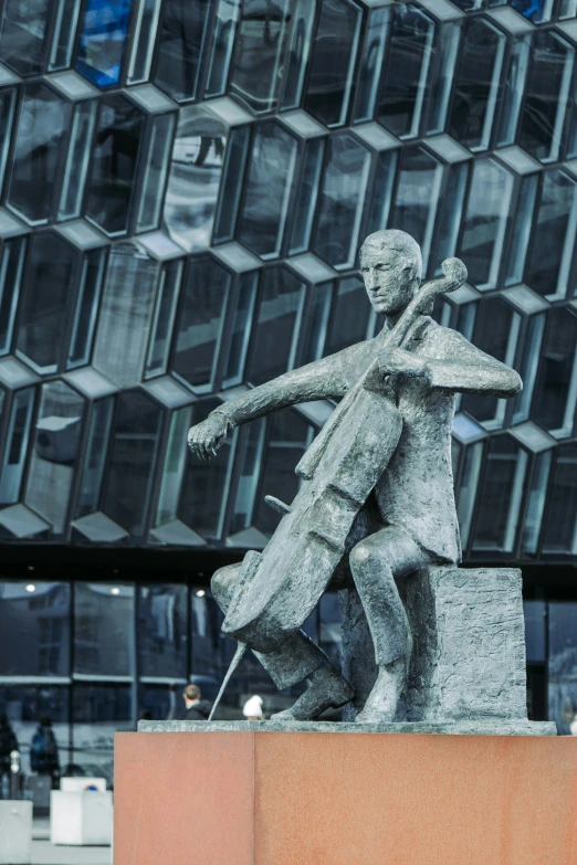 a statue on a block of granite in front of an office building