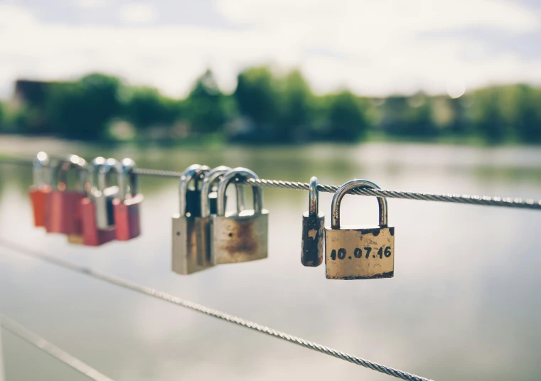 padlocks attached to a rope above a river