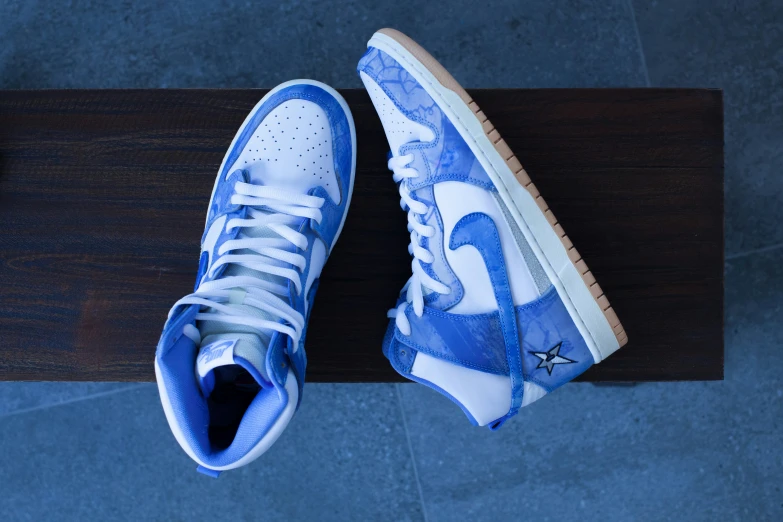 a pair of sneakers sitting on top of a wooden table