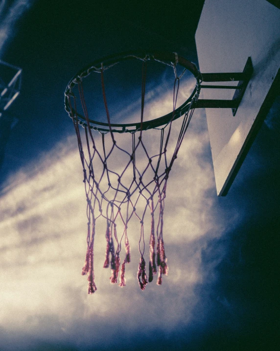 the hoop is in front of the clouds on the basketball court