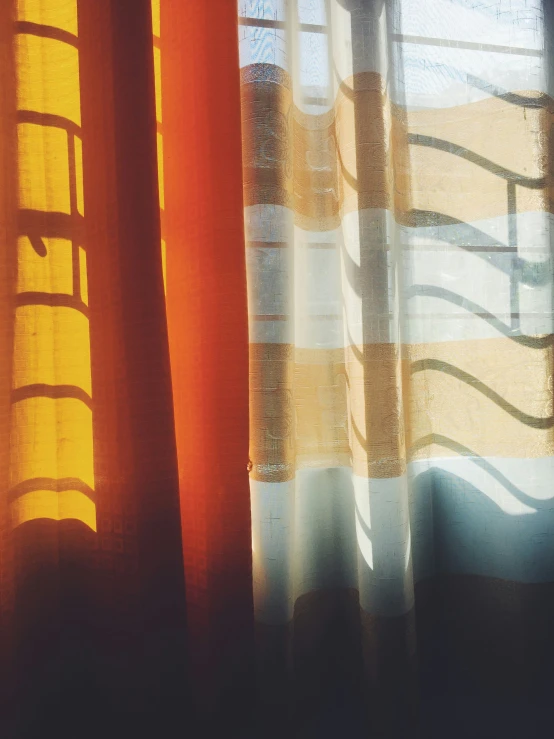 sunlight is streaming through some sheered curtains